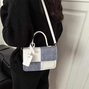 Minimalist rectangular crossbody bag with contrast stitching and fashion tag accessory