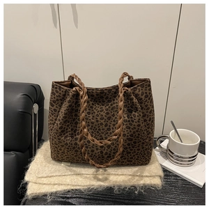 Primer plano del gran bolso tote de leopardo con asas trenzadas marrones y tela suave