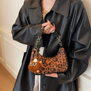 Chic leopard print crescent underarm bag with gold chain strap and plush charm