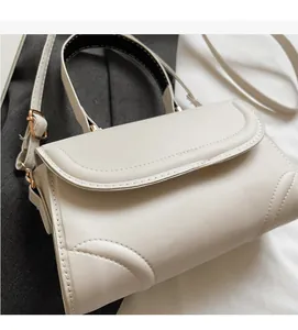 Close-up of off-white faux leather handbag with fine stitching and gold metal hardware
