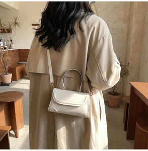 Schicke beige kleine Klappentasche mit Tragegriff und Riemen in minimalistischem Café-Stil
