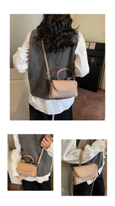 Detailansicht einer beige Mini-Ledertasche mit glatter Textur und geschwungener Klappe