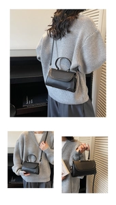 Details der schwarzen matten Lederhandtasche mit gebogenem Griff und silbernen Schnallen