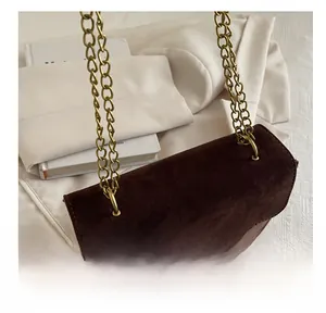 Detailansicht der dunkelbraunen Wildleder-Schultertasche mit goldenem Schloss und Kette