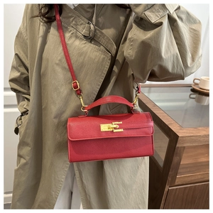 Détail du sac bandoulière en cuir Saffiano rouge avec fermoir doré sur mannequin