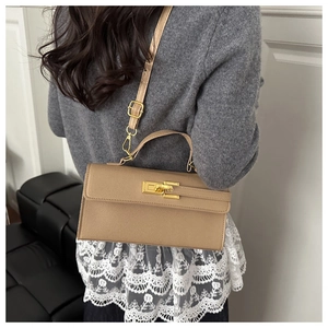 Détail du sac à bandoulière en cuir kaki avec fermoir doré et bandoulière fine