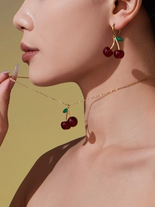 Close-up of a cherry jewelry set with red crystal pendants on a female model