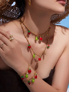 Detail of summer fruit charms on gold jewelry set with strawberries and watermelons
