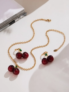 Detail of red cherry pendant necklace and earrings set with polished resin finish