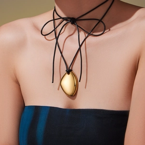 Golden bean pendant on black leather cord long necklace with irregular geometric design
