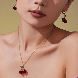 Chic red cherry jewelry set featuring a delicate necklace and matching drop earrings