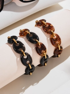 Close-up of tortoise shell resin and 18k gold-plated metal links on luxury bracelet