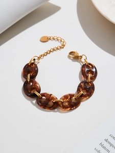 Detailed shot of 18k gold-plated chain bracelet with amber resin oval links and clasp