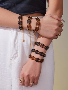 Detail of pig nose resin link bracelet with 18k gold plating and amber tortoiseshell links