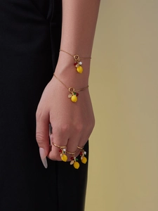 Detail of lemon pendant jewelry set with yellow zircons and golden chains on model