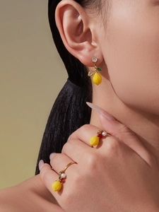 Détail de parure bijoux citron avec boucles d'oreilles zircon 5A et bagues sur modèle