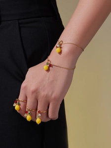 Détail d'un ensemble bracelet et bagues avec pendentif citron jaune, zircon et perles