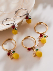 Vue macro de pendentifs citron avec zircons et feuilles en émail sur montures de bague