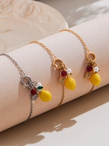 Gros plan de colliers pendentif citron avec zircon 5A et perles sur présentoirs