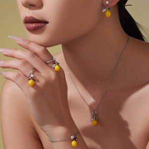 Parure de bijoux citron avec zircon jaune, perles et chaîne argentée sur mannequin