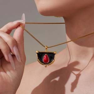 Collier chaîne serpent dorée avec pendentif en émail noir et gemme rouge en goutte