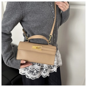 Détail d'un sac à main kaki en cuir avec fermoir doré et texture grainée élégante