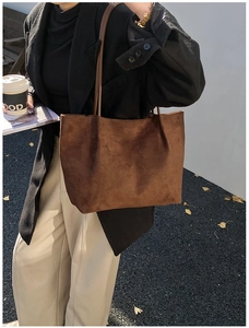 Outdoor model holding a dark brown suede tote bag for daily urban commuting style