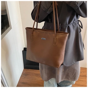 Détail du sac cabas en cuir grainé marron avec de fines bandoulières élégantes