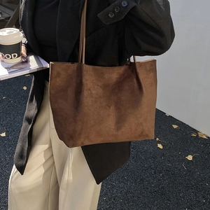 Brown frosted suede tote bag with stitching detail shown in an autumn street setting