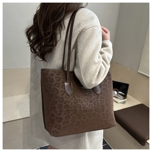 Detail of dark brown leopard print tote bag showing texture and slim shoulder straps