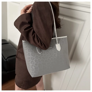 Detail of grey leopard print tote bag with white FASHION text and silver shoulder straps