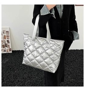 Vue latérale du grand sac cabas argenté matelassé avec une large bandoulière