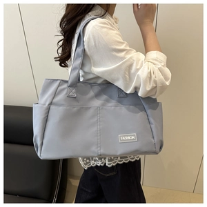 Modell mit hellblauer Nylon-Tragetasche mit mehreren Taschen für den täglichen Weg