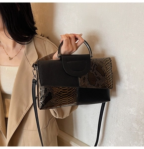 Gros plan d'un sac à main en patchwork de serpent avec poignée en métal et bandoulière