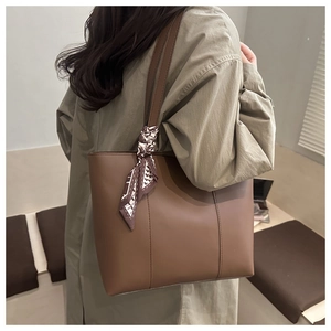 Brown leather tote bag with houndstooth scarf detail shown on trench coat model