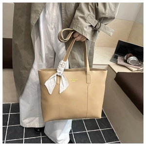 Detail of khaki leather tote bag with stylish silk scarf and tidal dryness bags logo