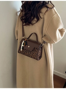 Détail du patchwork léopard avec boucle dorée et breloque en perles sur le sac