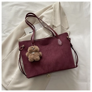 Detail der weinroten Shopper-Tasche aus Wildlederimitat mit braunem Plüschbär-Anhänger