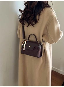 Vue mannequin d'un sac carré vintage marron avec breloque sur manteau en laine