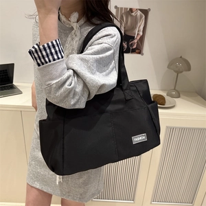 Large black nylon shoulder tote bag for commuting with side pocket and sturdy strap
