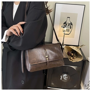 Vue détaillée du sac bandoulière vintage en cuir marron foncé avec boucle dorée