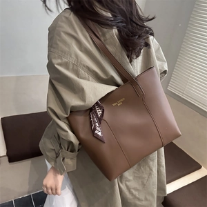 Large dark brown leather tote bag with gold lettering and decorative floral scarf detail