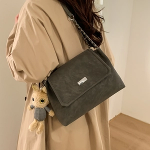 Große dunkelgraue Wildleder-Einkaufstasche mit Silberkette und Hasenanhänger am Model