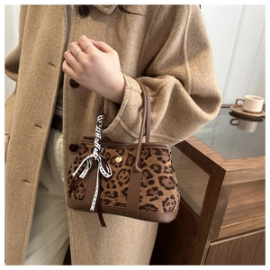 Détail du sac à main léopard avec texture pelucheuse, garniture en cuir et nœud en dentelle