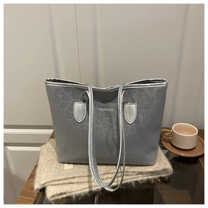 Détail du grand sac cabas imprimé léopard gris avec bandoulières argentées et texte