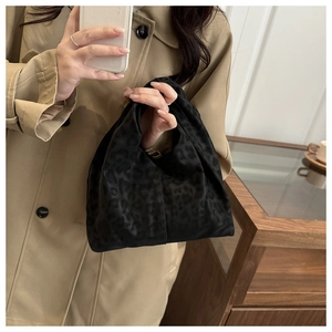 Mirror selfie showing a black leopard pattern tote bag with satin fabric and sleek handles