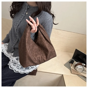 Detail of leopard print hobo bag showing faux suede texture and wide handle design