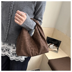 Detail view of large leopard print tote bag with soft pleated suede texture and top handle