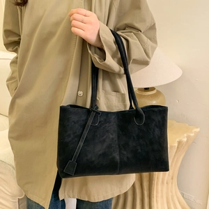Minimalist black matte suede tote bag for women shown in a modern home interior setting