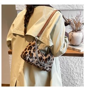 Détail du sac sous l'aisselle en peluche léopard avec chaîne argentée et bandoulière en cuir